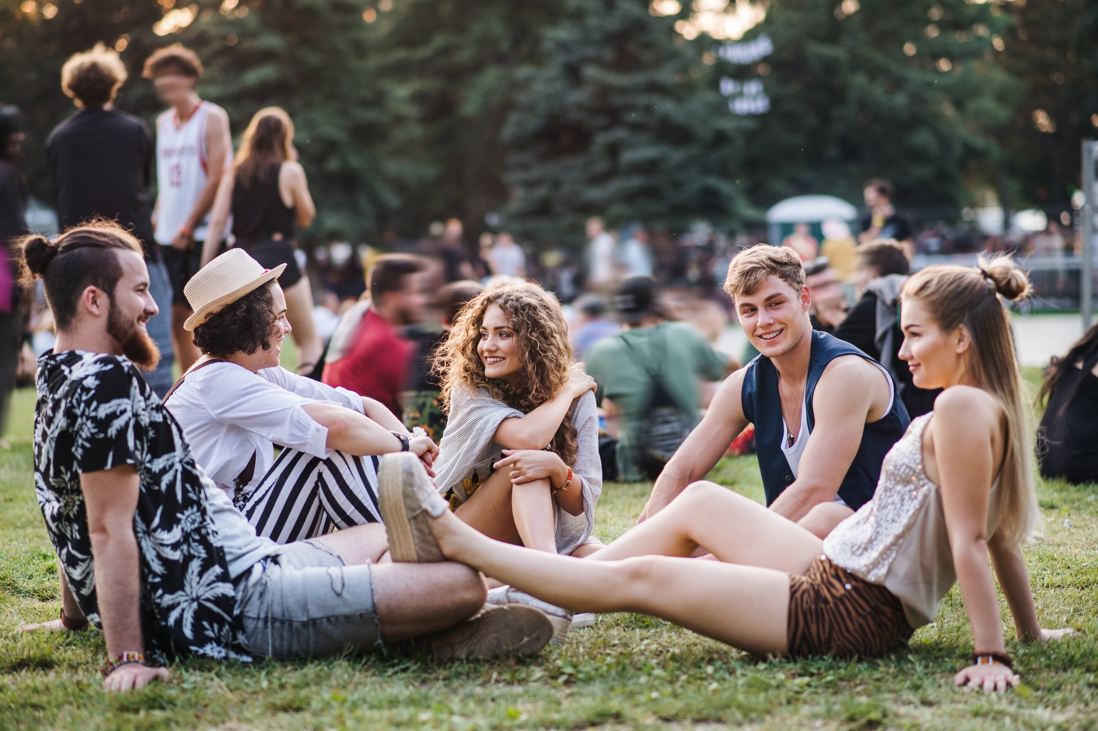 Group of Young People Sitting on Ground at Summer Festival